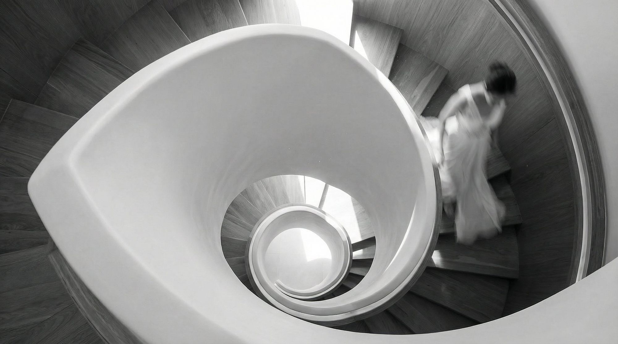 Sculptural spiral staircase in a Beverly Hills One estate, light cascading through the helix